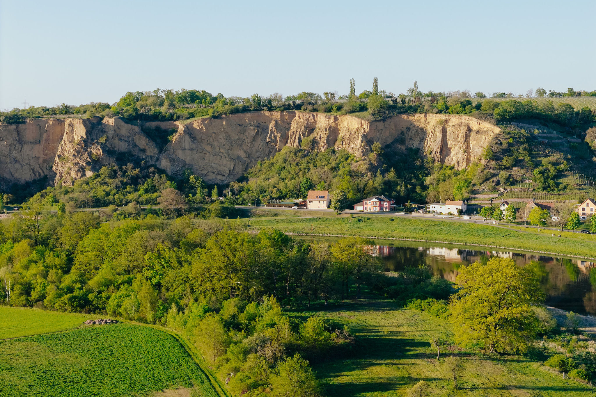 Die Felsen am anderen Elbufer, davor Wiesen und der Fluss